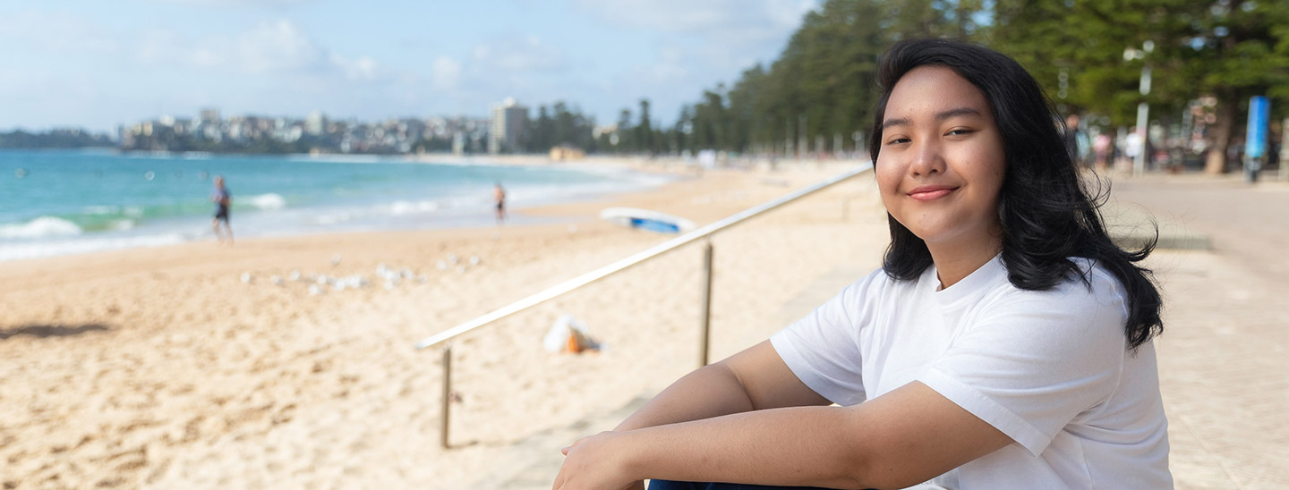 Student sitting on beach