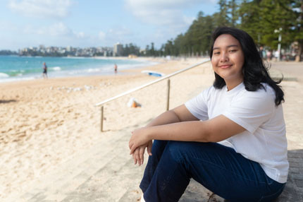 Student sitting on beach